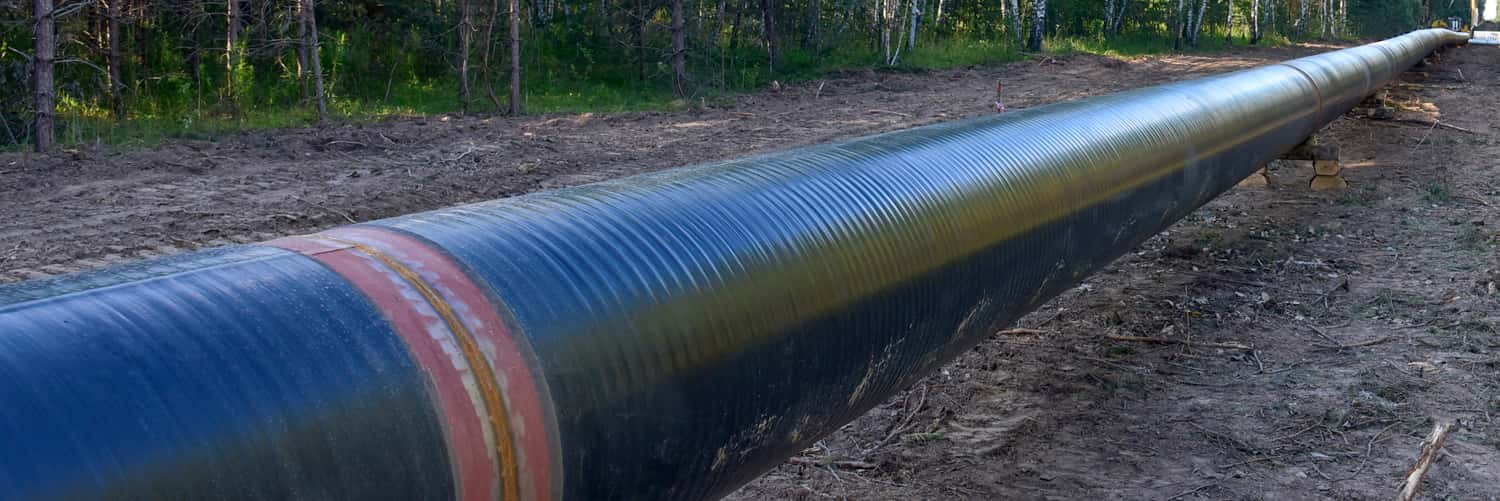 A close-up wide shot of an oil pipeline tunneling through the soil.